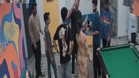 CCTV screenshot showing a confrontation between a man and a woman inside a Bengaluru hostel common area