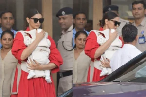 Actor Deepika Padukone holding her infant while stepping out in Mumbai, surrounded by security personnel