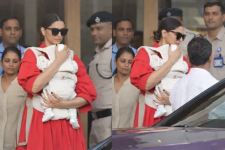 Actor Deepika Padukone holding her infant while stepping out in Mumbai, surrounded by security personnel