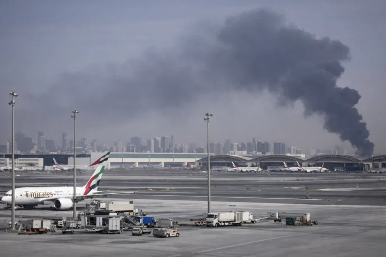 Thick smoke rising near Dubai International Airport as aircraft remain parked on the runway following a security incident