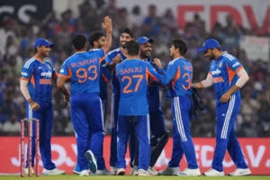 Indian cricket players celebrating a wicket during a T20 World Cup match as teammates gather on the field
