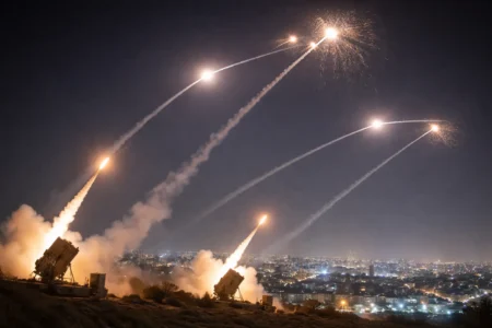 Israeli air defense system intercepting incoming missiles over a city during the ongoing conflict with Iran
