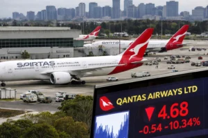 Qantas aircraft parked at Sydney Kingsford Smith Airport with city skyline in background