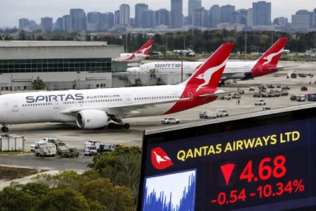 Qantas aircraft parked at Sydney Kingsford Smith Airport with city skyline in background