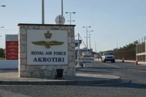 Main entrance sign of RAF Akrotiri military base in Cyprus with security fencing and checkpoint in background